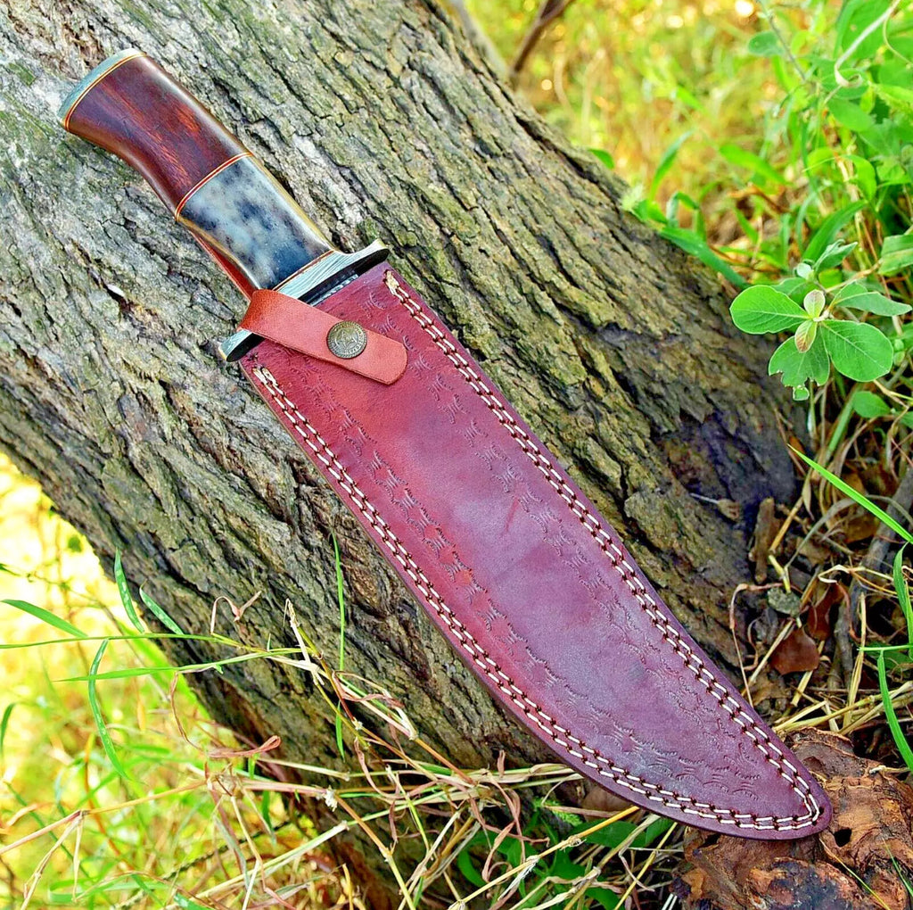 Handmade Damascus steel Bowie knife with rosewood and colored bone handle, Damascus steel guard, and leather sheath.