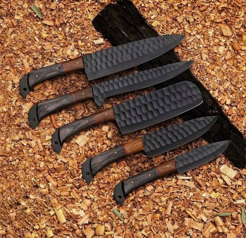 Handmade kitchen knife set by Knives Gear Garage with stainless steel blades and wooden handles on a countertop.