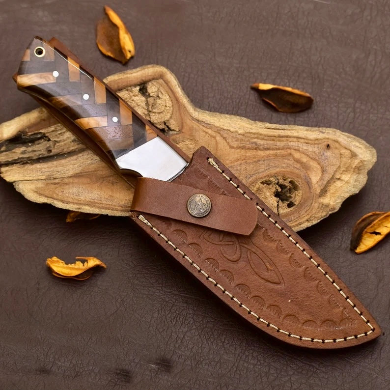 Handmade D2 steel hunting knife with leather sheath from Knives Gear Garage, featuring a sharp blade and textured handle.