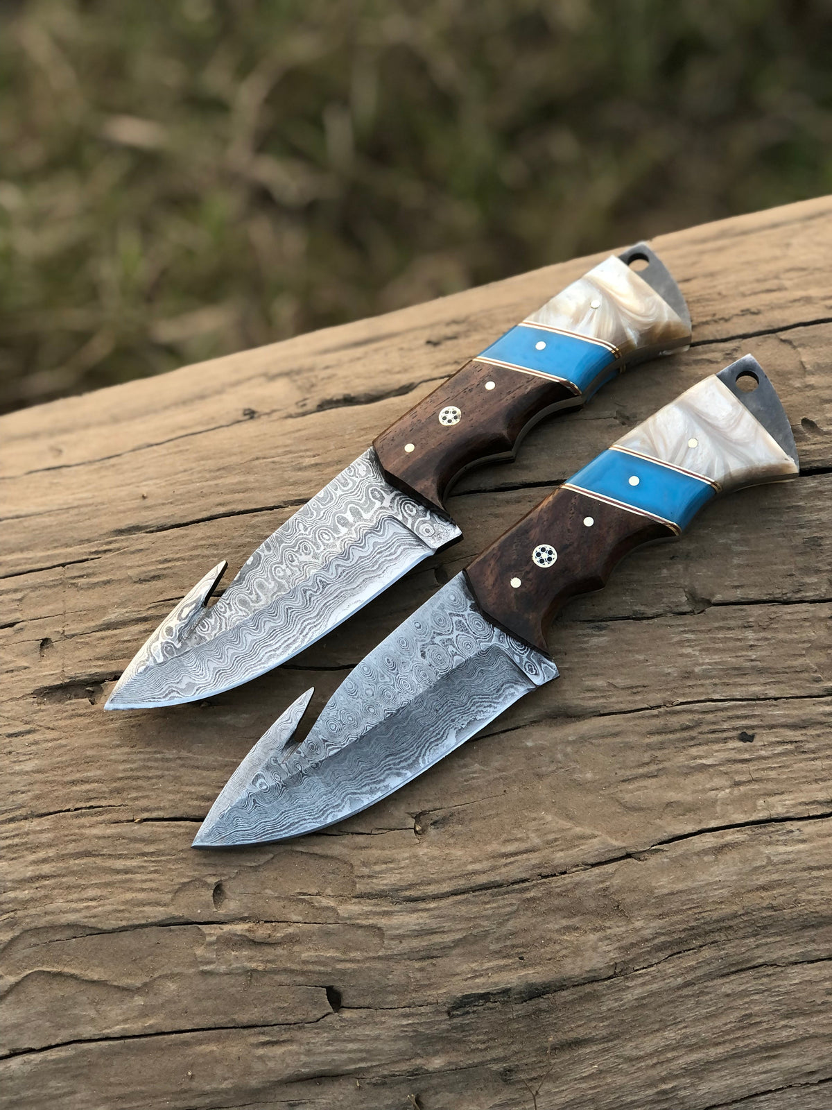 Custom handmade Damascus steel Guthook hunting knife with intricate pattern and leather handle from Knives Gear Garage.