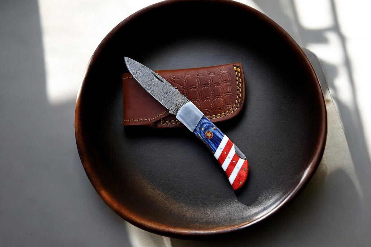 Handmade Damascus folding knife with exotic Pakka wood handle, showcasing intricate blade pattern and polished wood details.