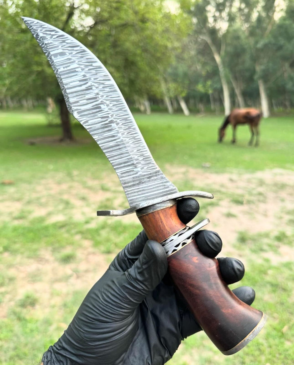 Custom handmade Damascus steel hunting Bowie knife with a leather handle and detailed blade design by Knives Gear Garage.