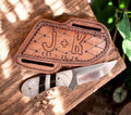 Handmade cowboy knife with epoxy resin handle and Damascus steel blade, displayed on a wooden surface.