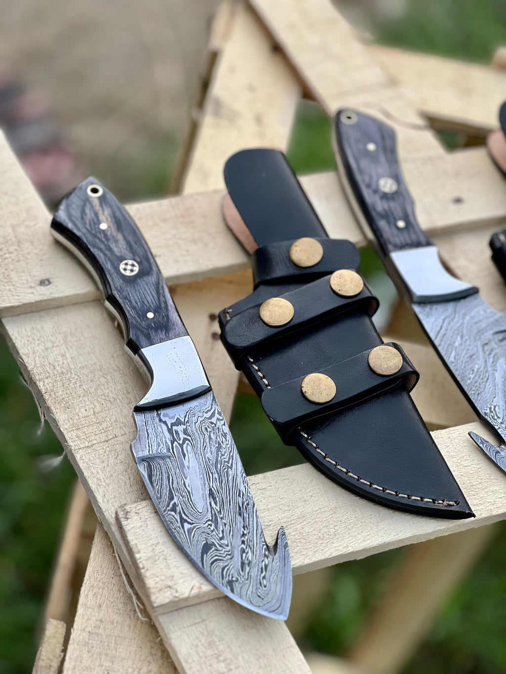 Custom handmade Damascus steel Guthook skinning knife by Knives Gear Garage, featuring a sharp, durable blade with intricate steel patterns.