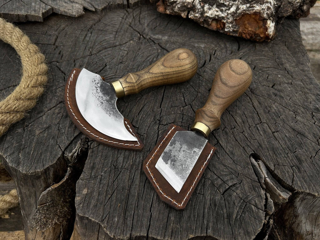 Two-piece Sharky Forged Steel Tools leather knife set with rounded and angled blades on a wooden surface.