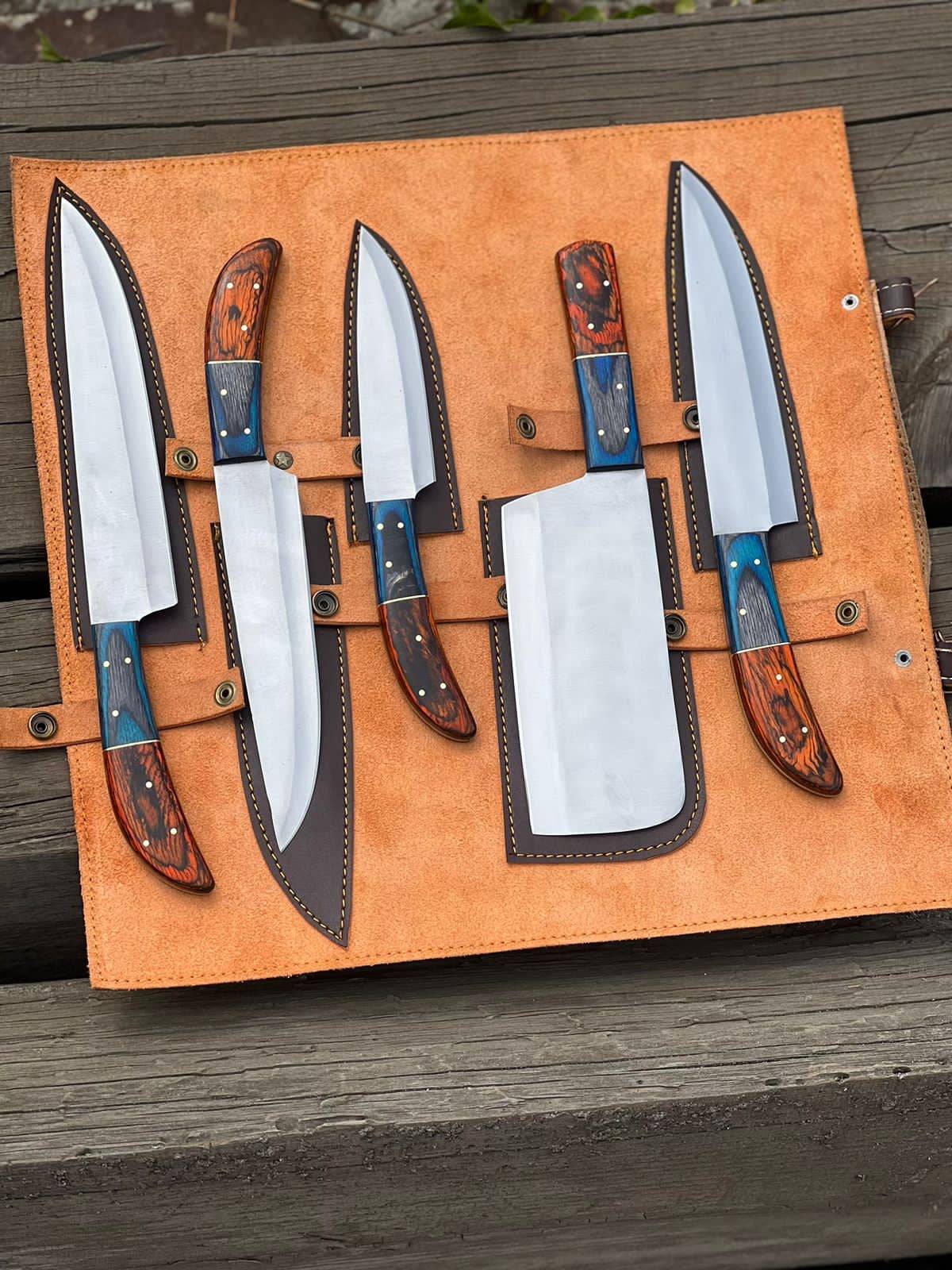 Handmade D2 steel kitchen knife set with wooden handles, crafted by Knives Gear Garage, displayed on a cutting board.