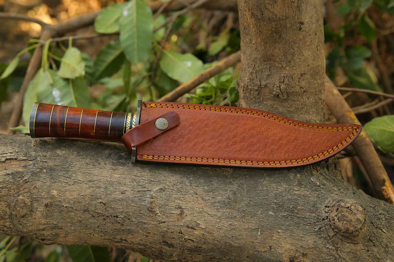 Handcrafted Damascus Steel Bowie Knife with rosewood and brass handle, Damascus steel guard, and leather sheath.