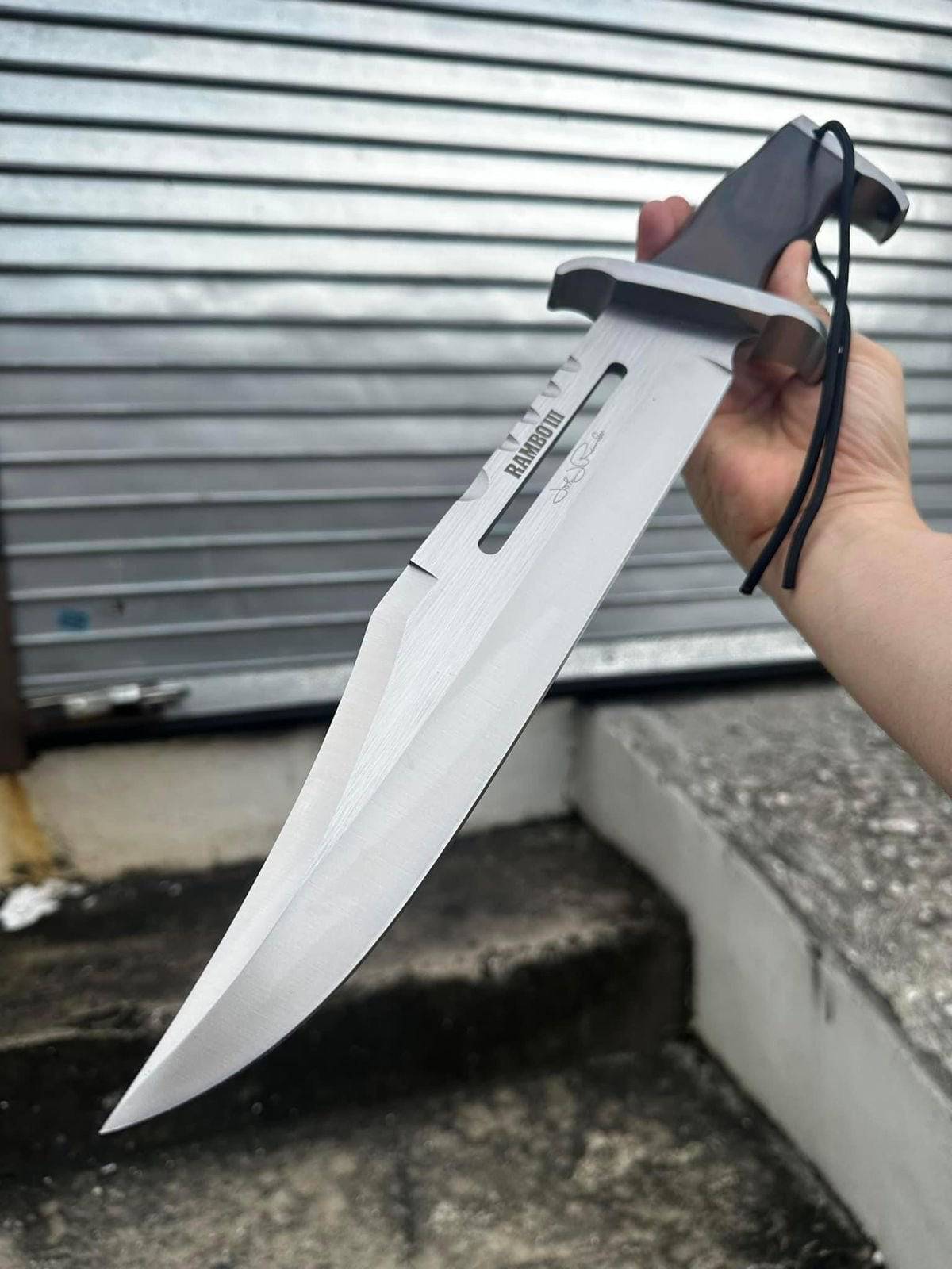 Close-up of the cskforged Rambo Knife with D2 steel blade, featuring a textured handle and rugged design.