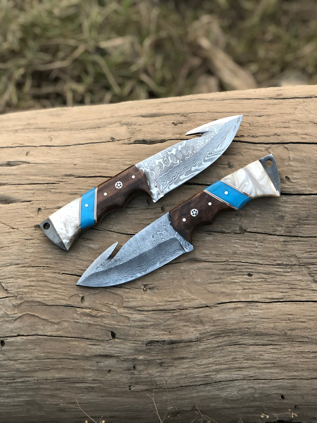 Custom handmade Damascus steel Guthook hunting knife with intricate blade pattern and leather handle, crafted by Knives Gear Garage.