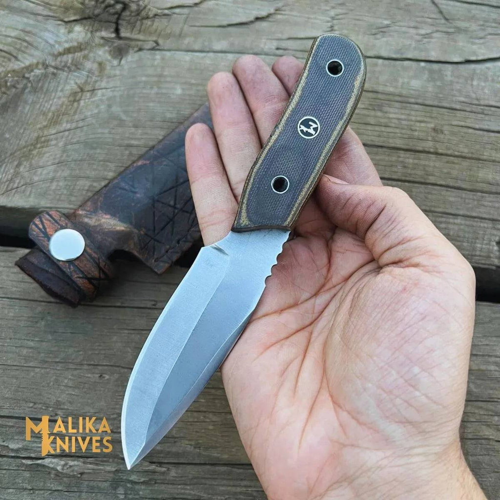Close-up of a handcrafted MALIKA KNIVES EDC knife with a sleek blade and textured handle, designed for everyday use and durability.