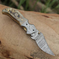 Damascus pocket folding knife with engraved handle, clip, and handmade design from Knives Gear Garage, ideal for everyday carry and gifting.