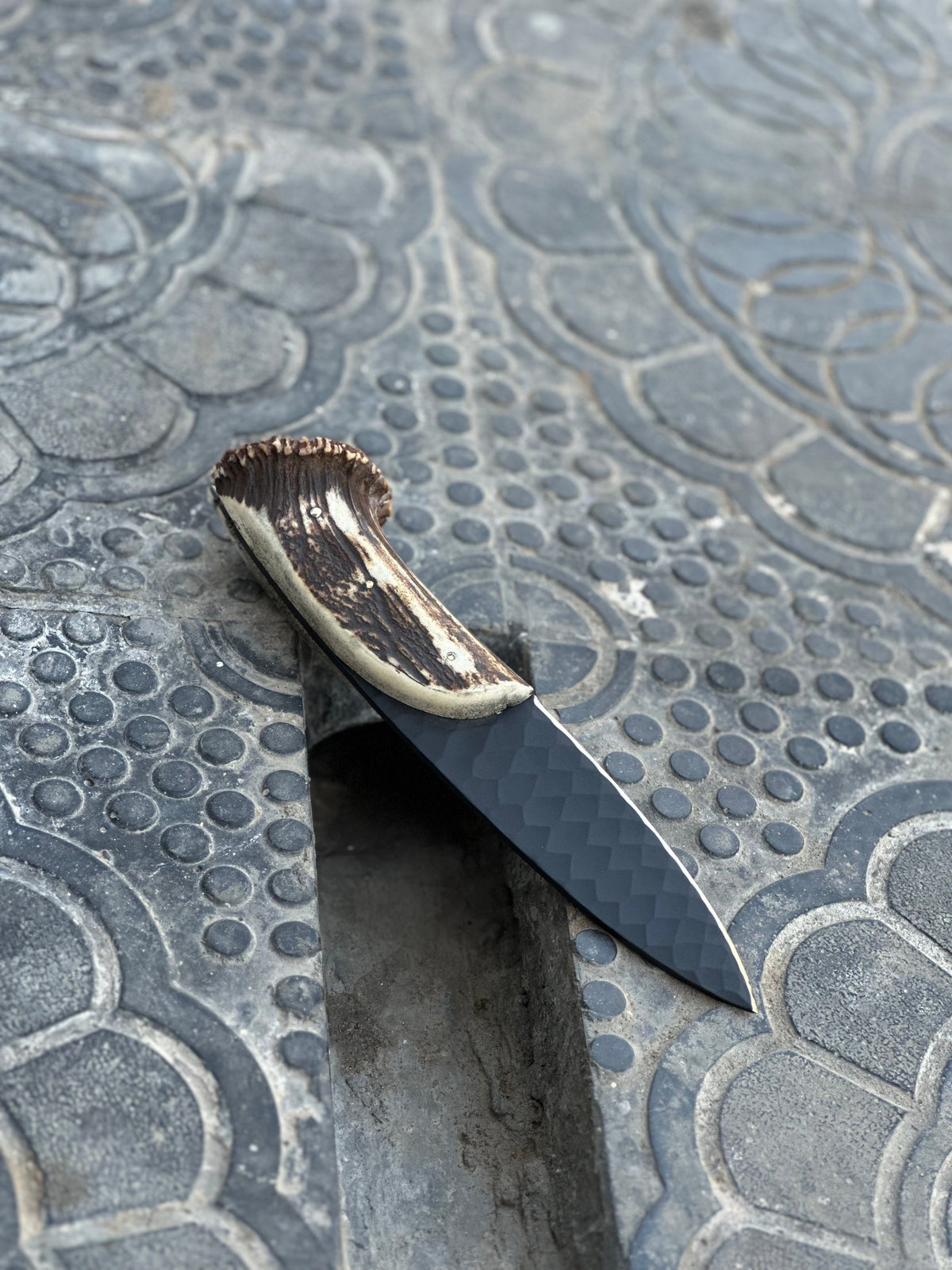 Hand forged steel hunting knife by Knives Gear Garage with a leather handle and sharp blade for outdoor hunting activities.