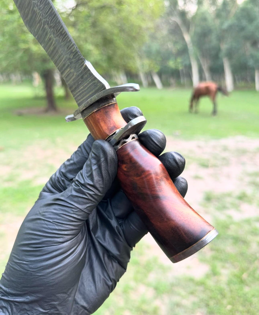 Custom handmade Damascus steel hunting Bowie knife with a leather handle and detailed blade design by Knives Gear Garage.