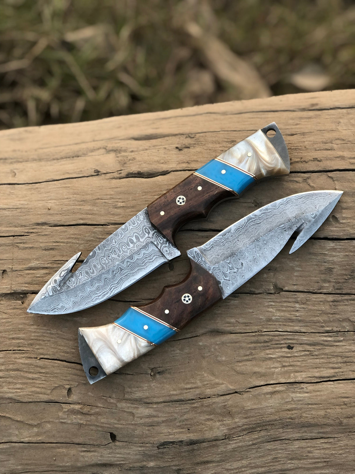 Custom handmade Damascus steel Guthook hunting knife with intricate blade pattern and durable handle, crafted by Knives Gear Garage.