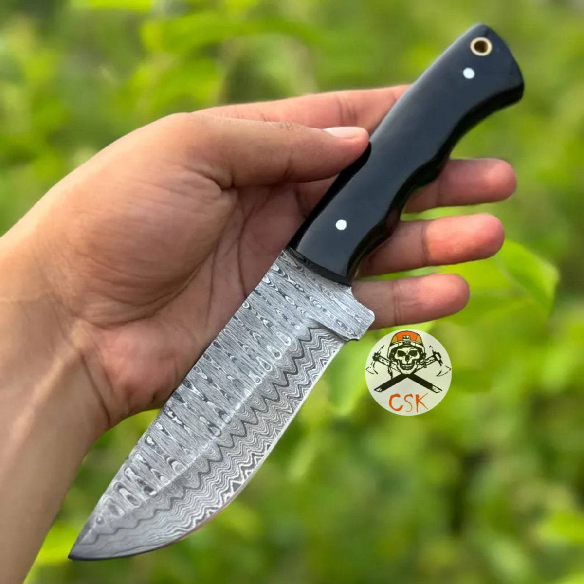 Pair of cskforged hunting knives with premium hand-forged Damascus steel blades and ergonomic black handles.