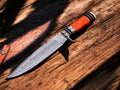 Handmade Damascus hunting knife with 11-inch blade and leather sheath, featuring intricate Damascus steel pattern and wooden handle.