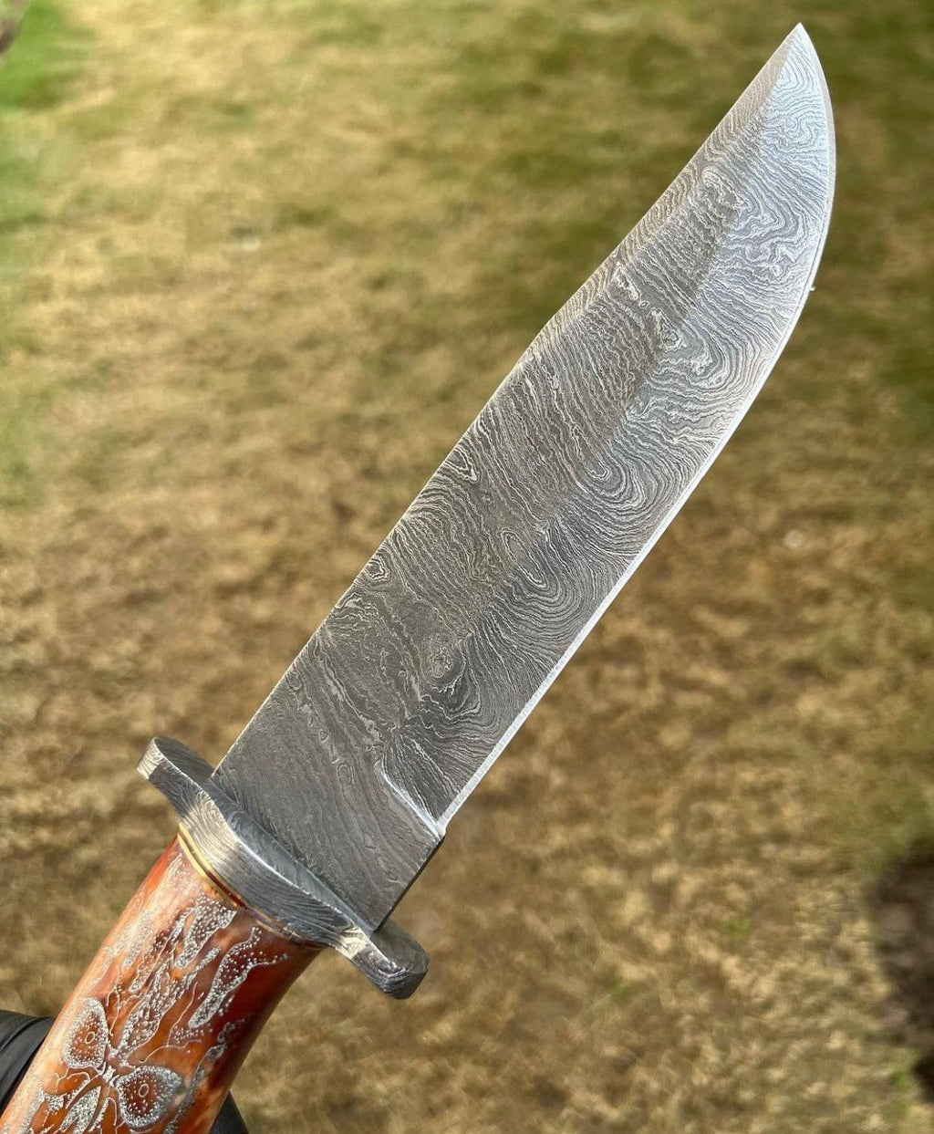Handmade Damascus hunting knife with skull handle by cskforged, featuring a sharp blade suited for camping and outdoor use.