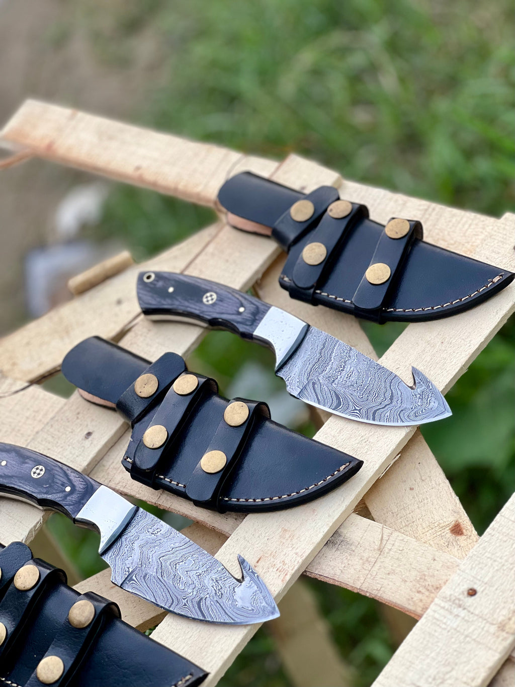 Custom handmade Damascus steel Guthook skinning knife with wooden handle, crafted by Knives Gear Garage for outdoor hunting and skinning.