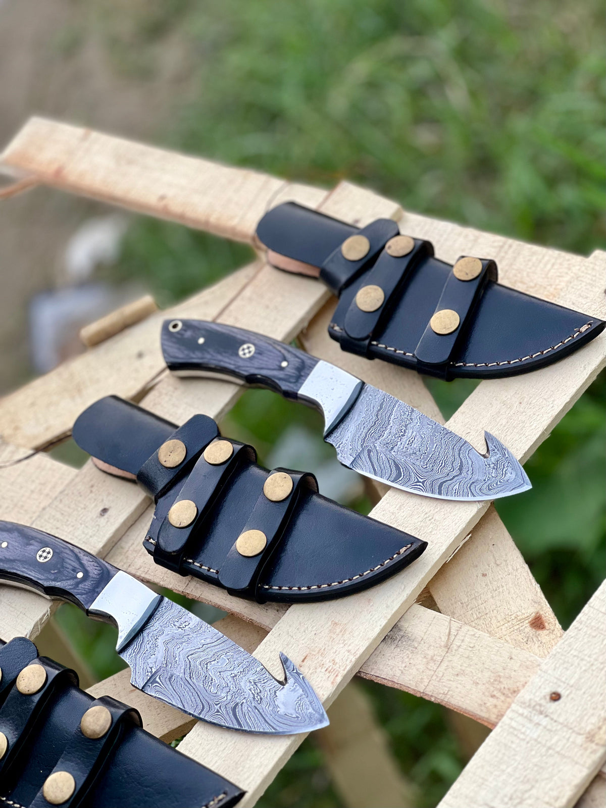 Custom handmade Damascus steel Guthook skinning knife with wooden handle, crafted by Knives Gear Garage for outdoor hunting and skinning.