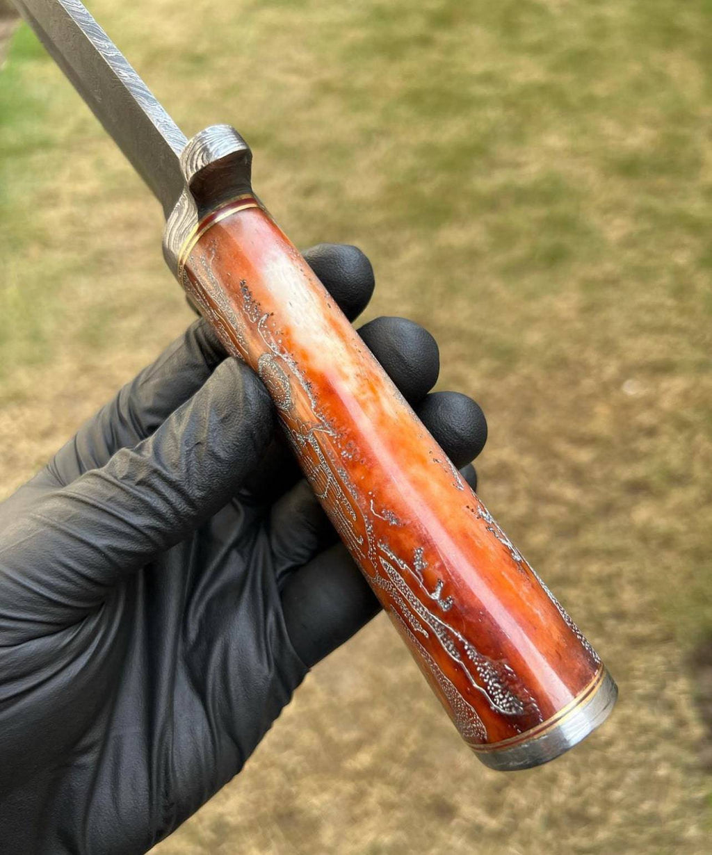 Handmade Damascus hunting knife with skull handle from cskforged, featuring a sharp blade ideal for camping and hunting.