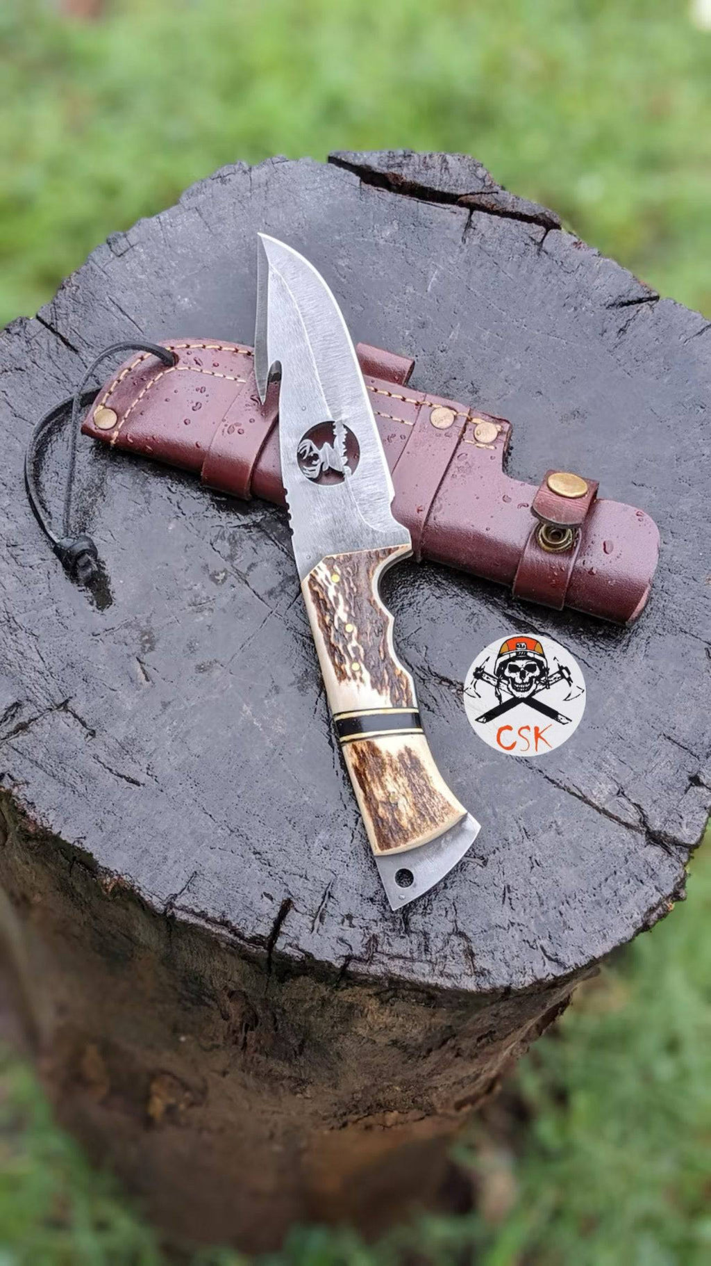 Handcrafted cskforged carbon steel hunting knife with antler handle, custom bushcraft survival blade on a wooden background.
