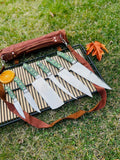 Custom Handmade J2 Steel Kitchen Knife Set by Knives Gear Garage, featuring G10 handles, steel bolsters, and a leather roll storage kit.
