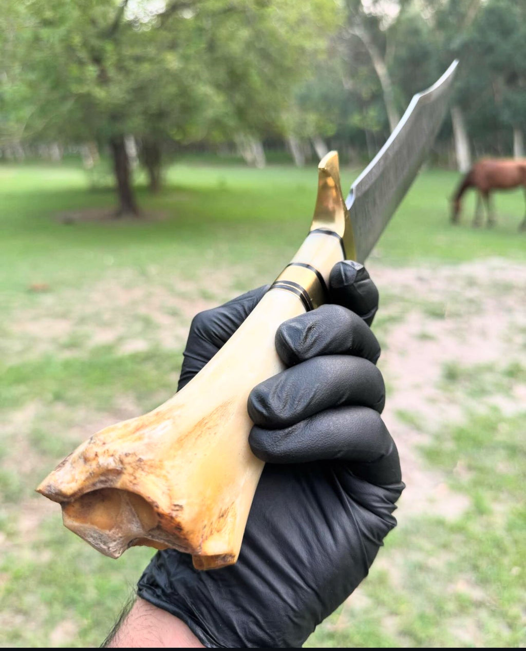 Custom handmade 16-inch Damascus steel Bowie knife with brass guard, camel bone handle, and leather sheath.