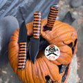 Custom black and orange striped hunting knife by cskforged, featuring a sharp blade and textured handle for outdoor survival.