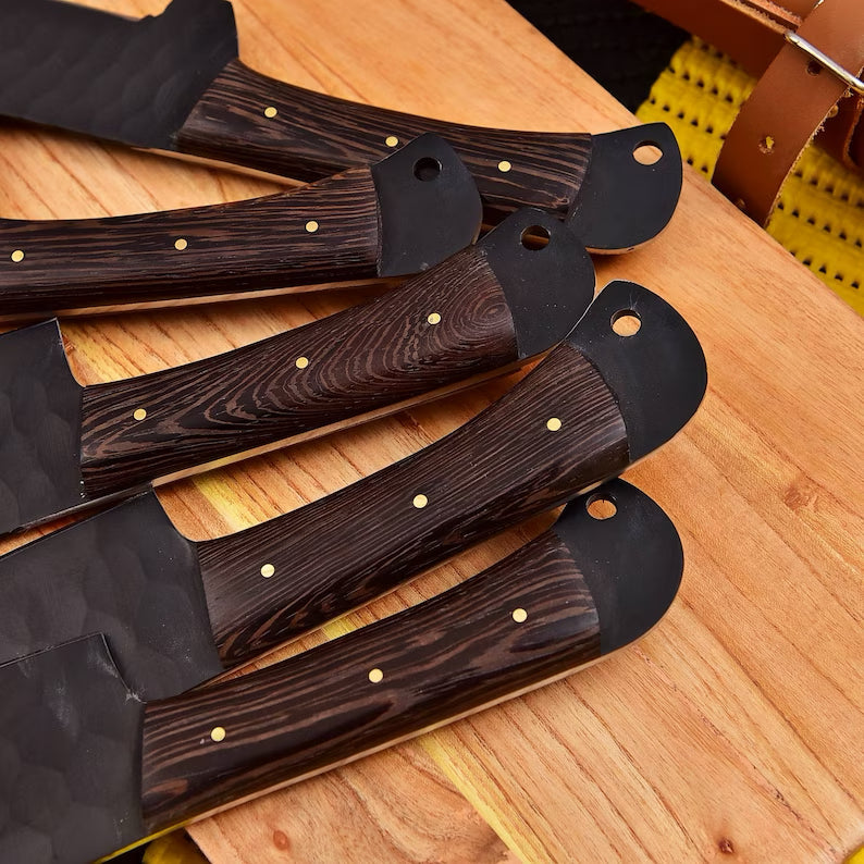 Set of seven stainless steel kitchen knives from Knives Gear Garage with black handles, arranged on a wooden cutting board.