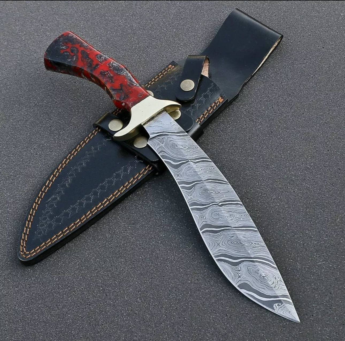 Custom handmade Damascus steel Bowie knife with resin handle, brass guard, and leather sheath by Knives Gear Garage.
