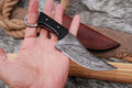 Custom handmade Damascus steel hunting knife with a buffalo horn handle by Knives Gear Garage, featuring a sharp blade and detailed craftsmanship.