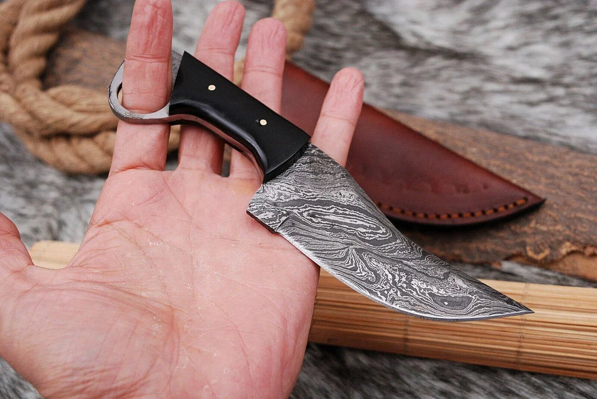 Custom handmade Damascus steel hunting knife with a buffalo horn handle by Knives Gear Garage, featuring a sharp blade and detailed craftsmanship.
