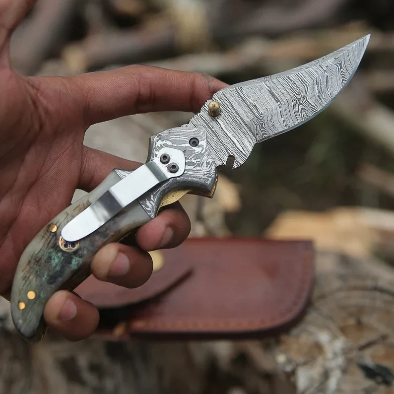 Damascus folding pocket knife with engraved handle, clip, and handcrafted design, ideal for everyday carry and gift-giving.