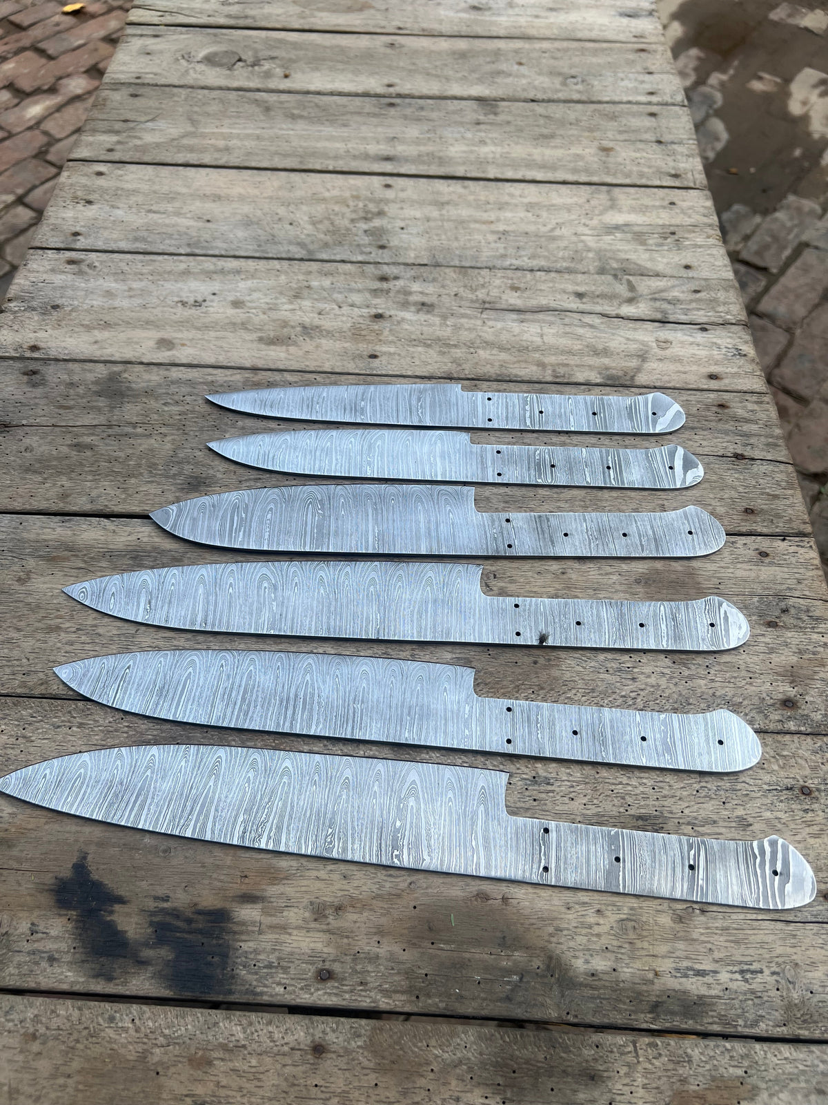 Six handmade Damascus chef knives with forged steel blades from JW SteelCrafts, ideal for custom knife making and culinary use.