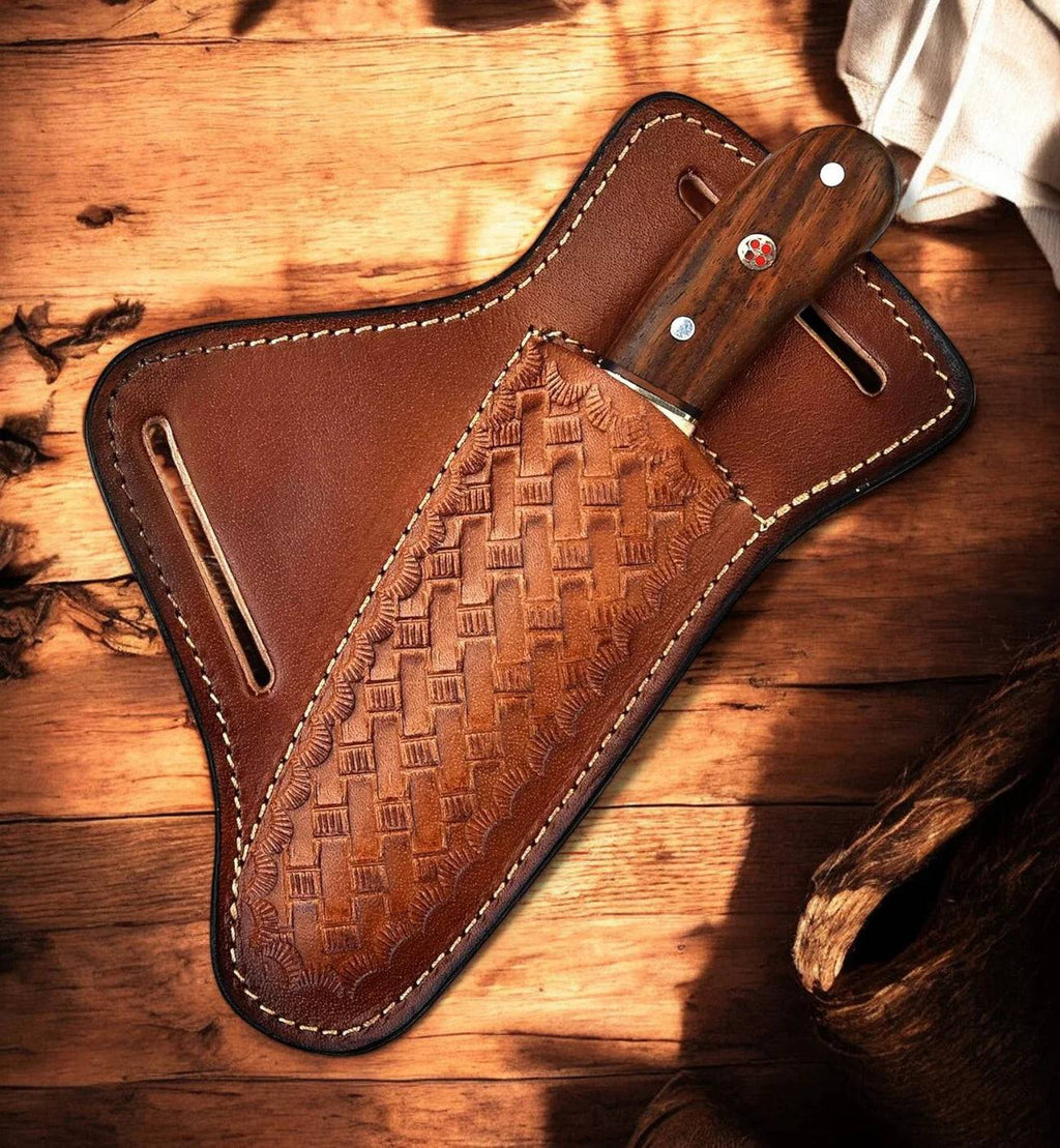 Custom handmade bull cutter knife by cskforged with leather sheath, featuring a sharp blade and rustic wooden handle.