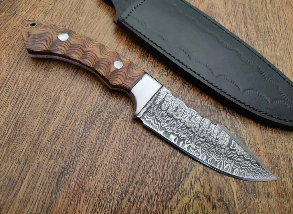 Custom handmade Damascus steel bushcraft camping and hunting knife by Knives Gear Garage with a textured handle and sharp blade.