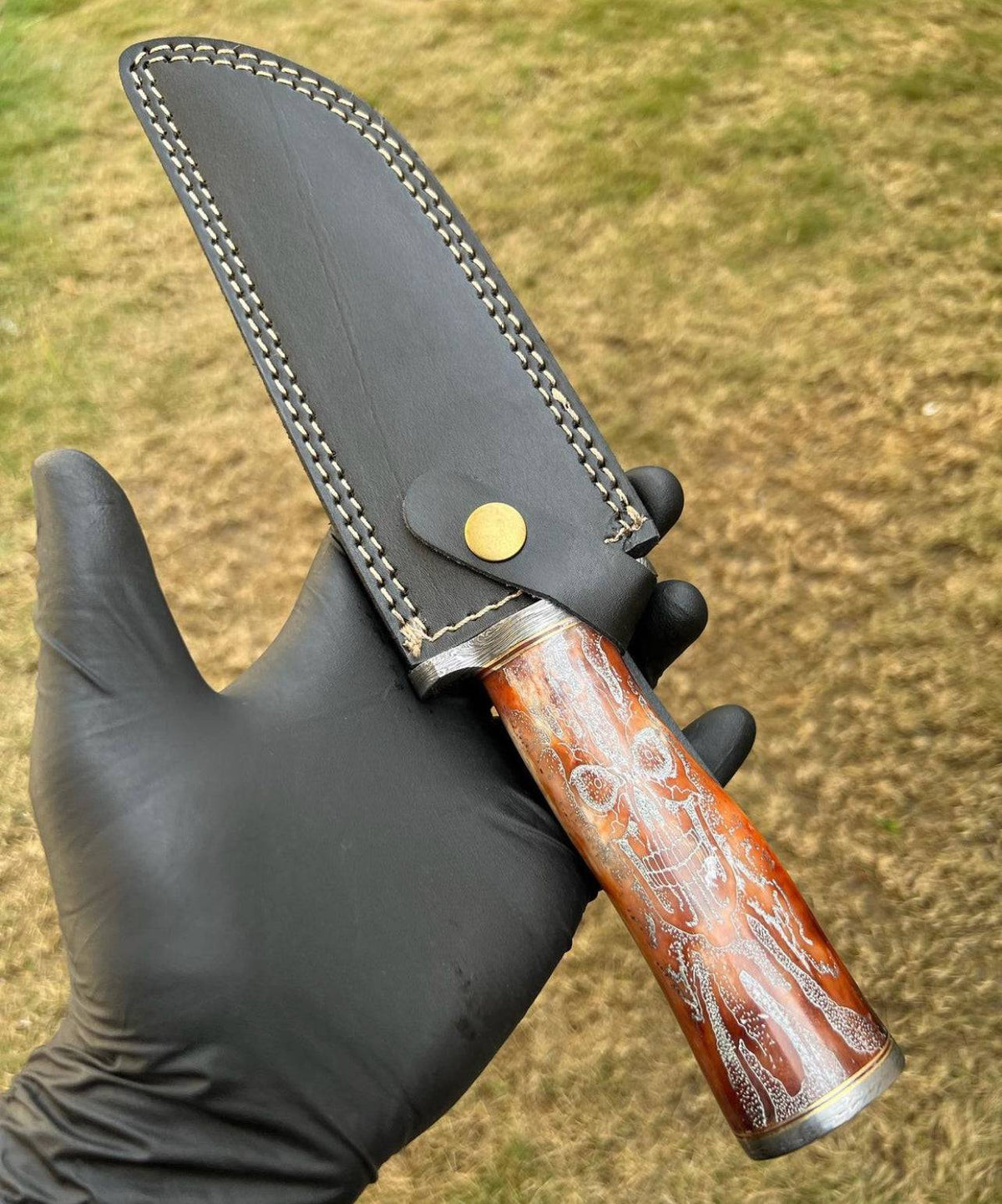 Handmade Damascus hunting knife with skull handle by cskforged, showcasing intricate blade details and rugged outdoor design.