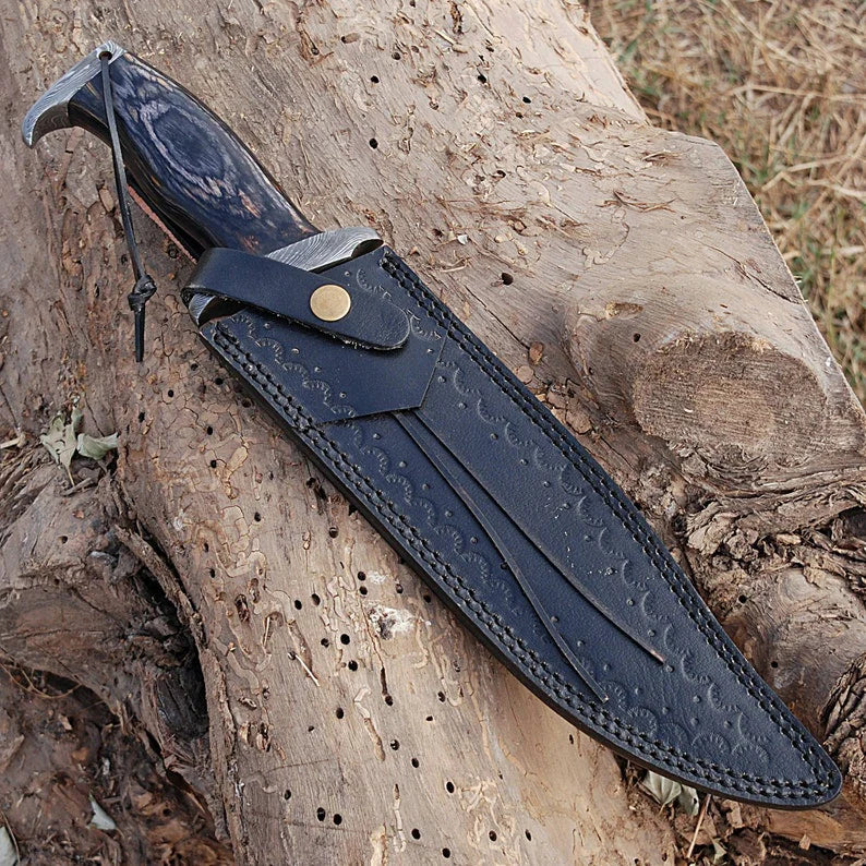 Custom handmade Damascus steel Rambo Bowie knife with brass wood handle and leather sheath, displayed on a neutral background.