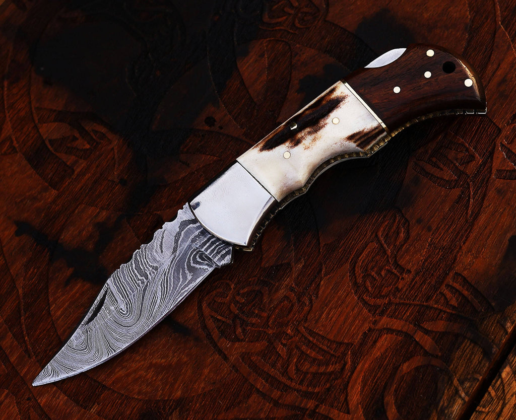 Damascus steel folding pocket knife with stag and rose wood handle by cskforged, handcrafted for durability and style.