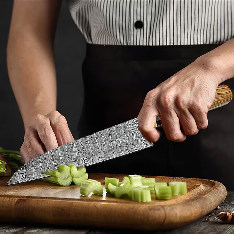 Custom handmade Damascus chef knife by Knives Gear Garage, featuring a patterned steel blade and ergonomic handle.