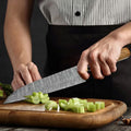 Custom handmade Damascus chef knife by Knives Gear Garage, featuring a patterned steel blade and ergonomic handle.
