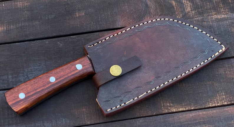 Handmade 10-inch Damascus steel cleaver with rosewood handle and leather sheath from Knives Gear Garage, showcasing the blade and handle.