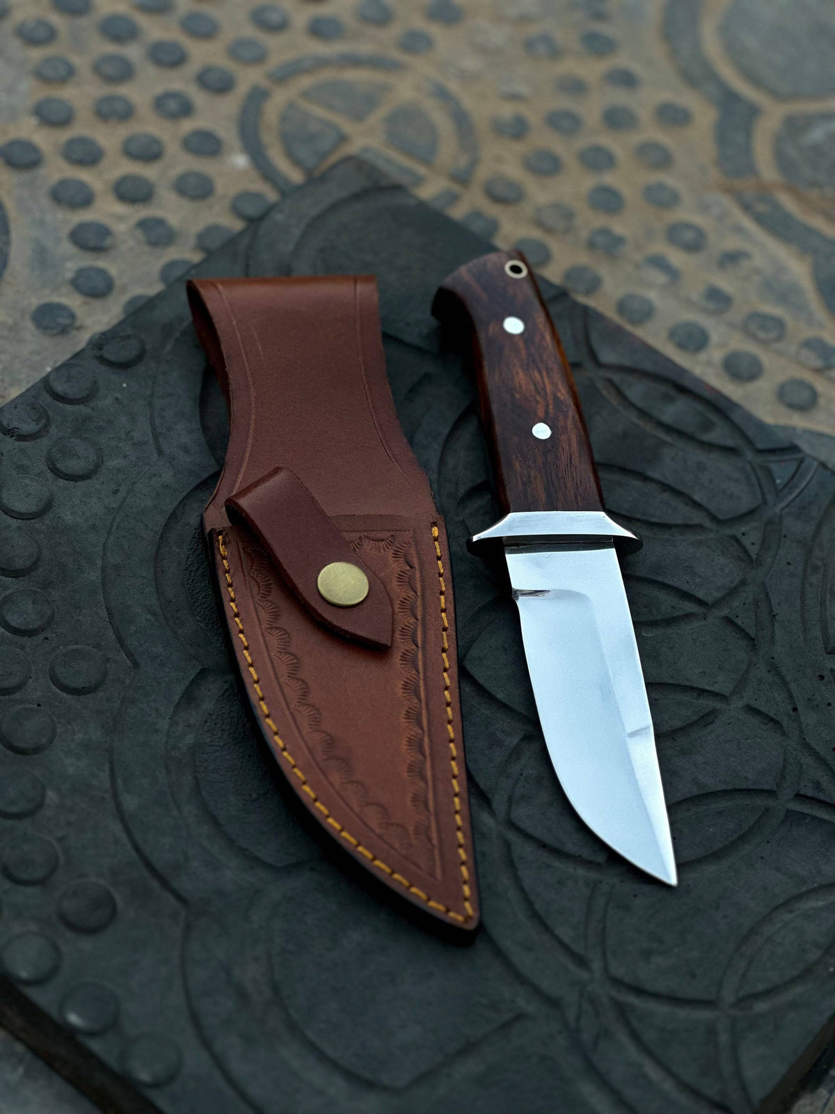 Handmade 1095 steel hunting knife with wooden handle from Knives Gear Garage, showcasing a sharp blade and rustic craftsmanship.