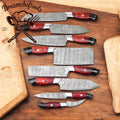 Hand-forged Damascus kitchen knife set with leather roll from Knives Gear Garage, featuring chef knives with intricate patterns and durable handles.