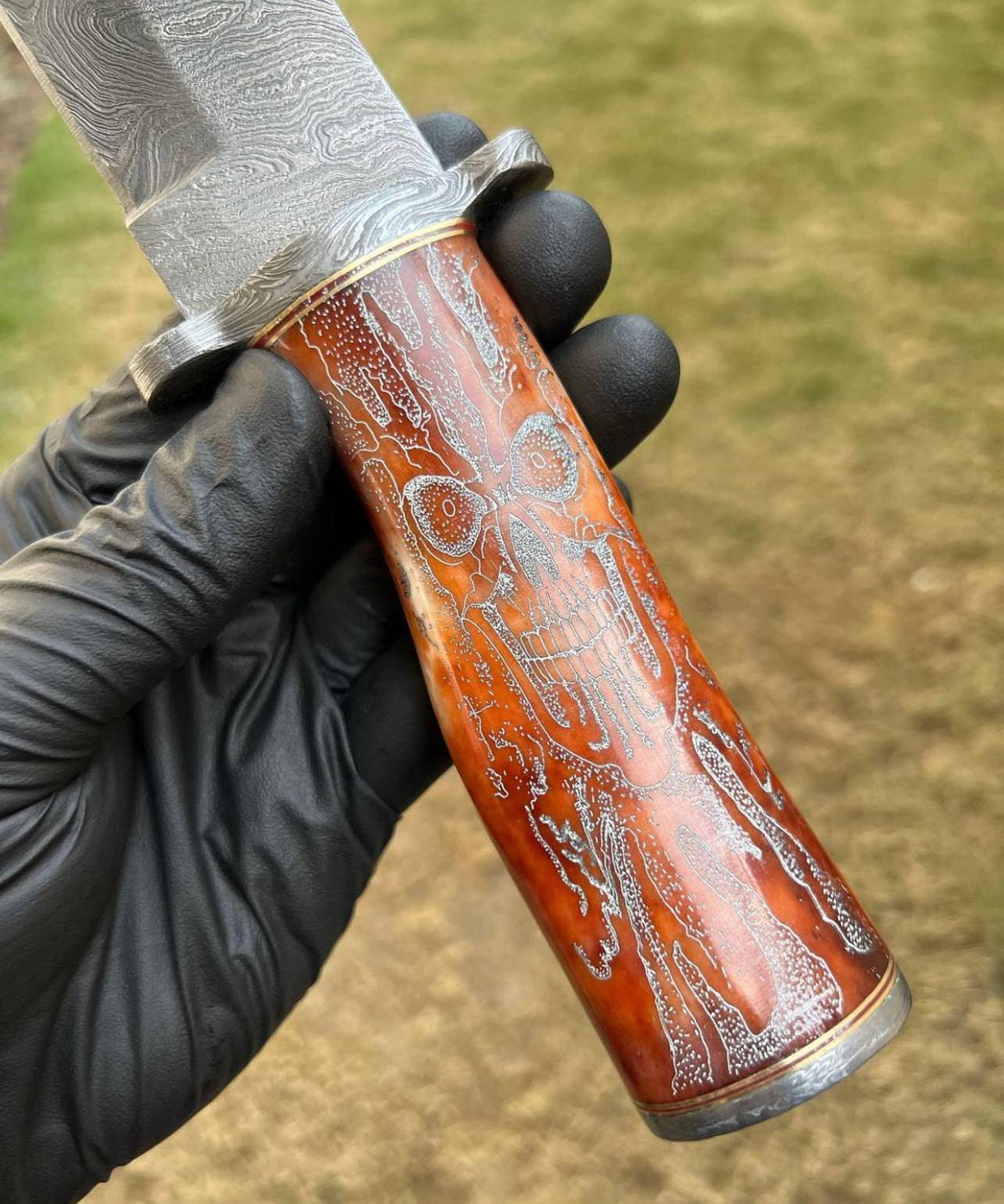 Handmade Damascus hunting knife with skull handle by cskforged, featuring a sharp blade suitable for camping and outdoor use.