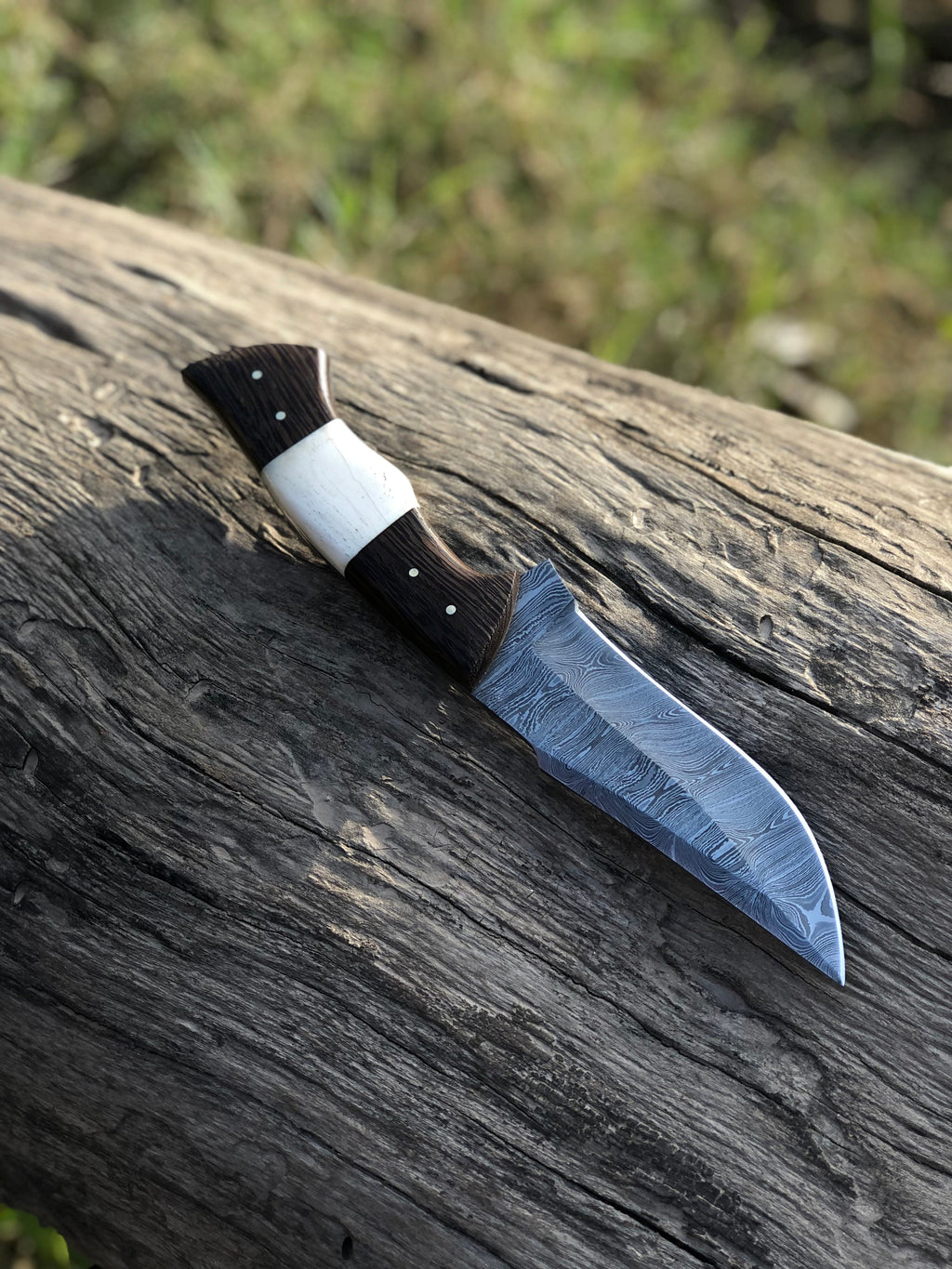 10.5-inch Wilderness Elite hunting knife by Knives Gear Garage with Damascus steel blade and bone-wenge wood handle.