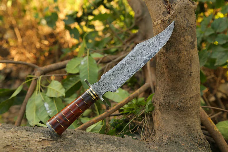 Handcrafted Damascus Steel Bowie Knife with rosewood and brass handle, steel guard, and leather sheath by Knives Gear Garage
