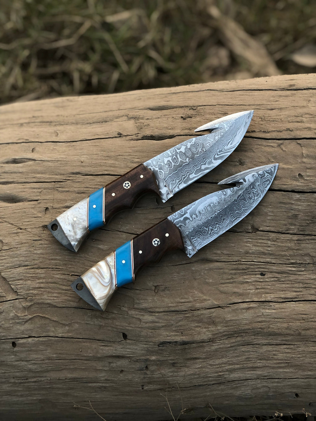 Custom handmade Damascus steel Guthook hunting knife with textured handle and sharp blade, crafted by Knives Gear Garage.