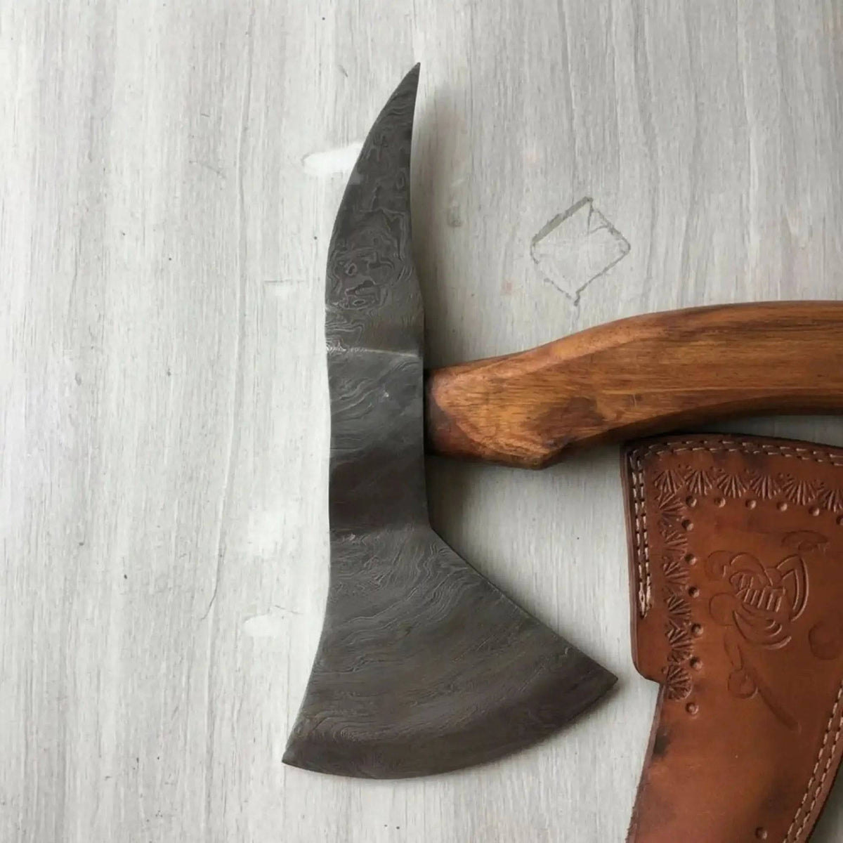 Handmade Damascus bearded spike tomahawk with forged spike poll, featuring a polished blade and wooden handle for camping and outdoor use.