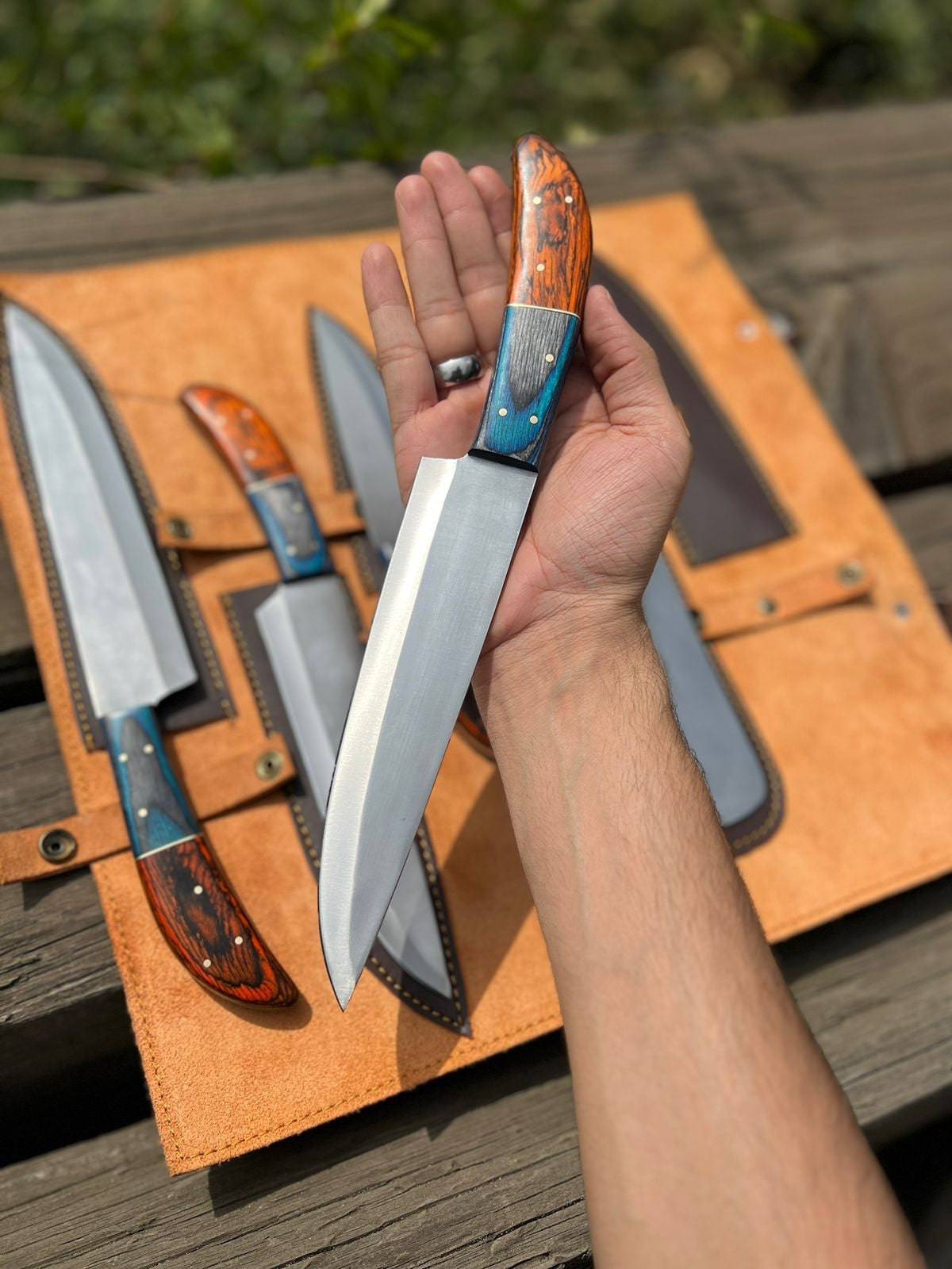 Handmade D2 steel kitchen knife set with wooden handles, featuring multiple knives displayed on a wooden cutting board.